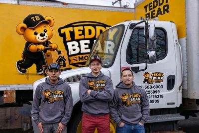 Three Teddy Bear Moving crew members with branded moving trucks